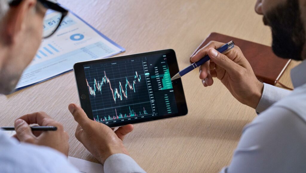 Trader consulting investor showing crypto trading chart using digital tablet for expert advisors.