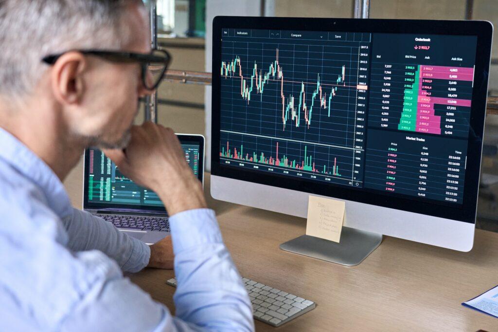 Crypto trader investor analyst looking at computer analyzing data on pc monitor.