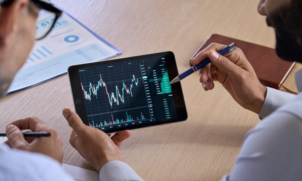 Trader consulting investor showing crypto trading chart using digital tablet for expert advisors.
